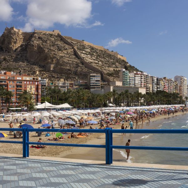 The beach at Alicante on the Costa Blanca in Spain. On the hill overlooking the city is Castillo de Santa Barbara which dates from the 16th century.